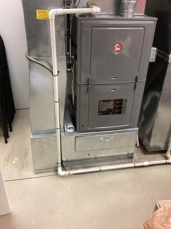 Conducted on-site assessment of existing Rheem HVAC system (Serial # W271524570) for air conditioning replacement estimate. Documented current furnace installation including PVC condensate drainage, metallic ductwork connections, and air handler configuration in basement utility space. Provided comprehensive replacement quote options per customer's requested timeframe.
