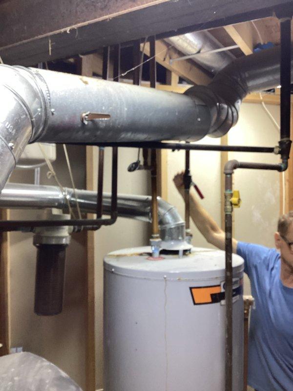 Completed on-site assessment of existing water heater installation in basement utility area. Inspected current unit, surrounding plumbing connections, gas lines, venting system, and clearance requirements. Documented existing configuration including water supply lines, gas piping with shutoff valve, temperature and pressure relief valve discharge piping, and exhaust ductwork connections. Photographed installation for replacement estimate preparation. Evaluated accessibility, structural support, and code compliance considerations for water heater replacement.