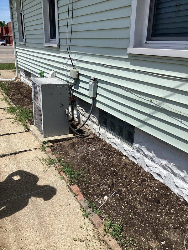 Completed comprehensive site assessment for full HVAC system replacement at residential property. Documented existing electrical service panel location and exterior utility connections to determine equipment placement and electrical requirements for new heating and cooling system installation.