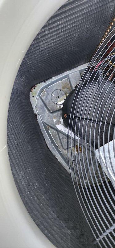 Completed routine maintenance on outdoor AC condensing unit. Inspected condenser coil and noted significant accumulation of dirt and organic growth causing greenish discoloration on coil fins. Checked fan motor assembly and protective grille, observing normal wear and minor surface oxidation consistent with outdoor exposure. Verified refrigerant lines and unit mounting on concrete pad, noting minor algae growth on cabinet base due to moisture exposure.
