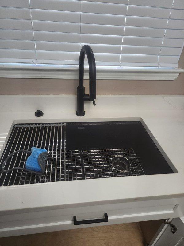 Completed install recall for kitchen faucet replacement. Verified proper installation of matte black pull-down spray faucet with undermount sink basin. Inspected under-sink plumbing connections, confirmed secure water supply line attachments with proper hose clamps, and verified garbage disposal integration with P-trap drainage system functioning correctly. All connections tested leak-free and installation completed to code.