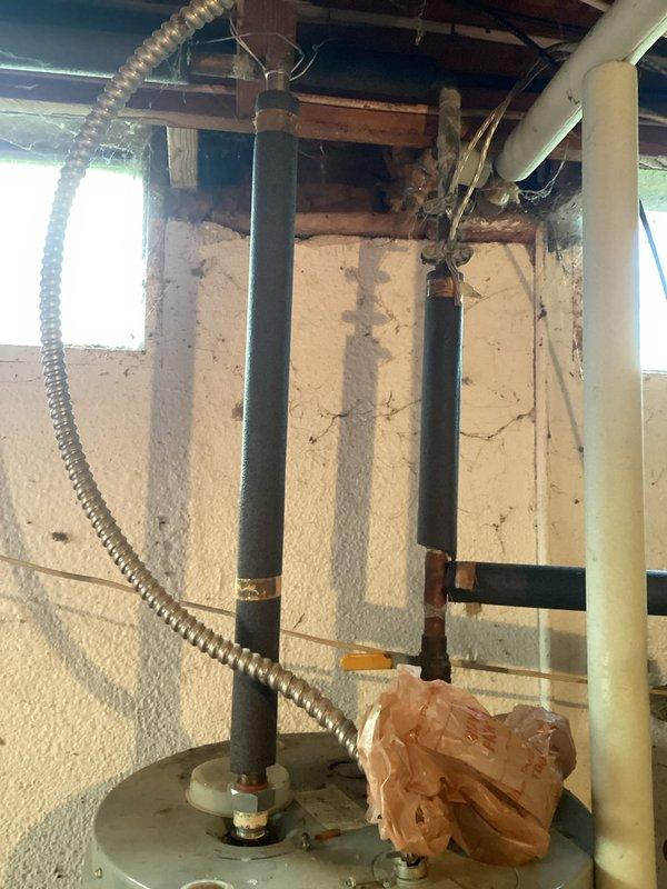 Provided estimate for electric water heater replacement serving well water system. Assessed existing cylindrical tank water heater in basement area with incoming cold water supply lines and evaluated electrical service at General Electric panel to confirm adequate capacity for new unit installation. Documented current equipment configuration including pipe connections, electrical conduit routing, and available workspace for replacement procedures.