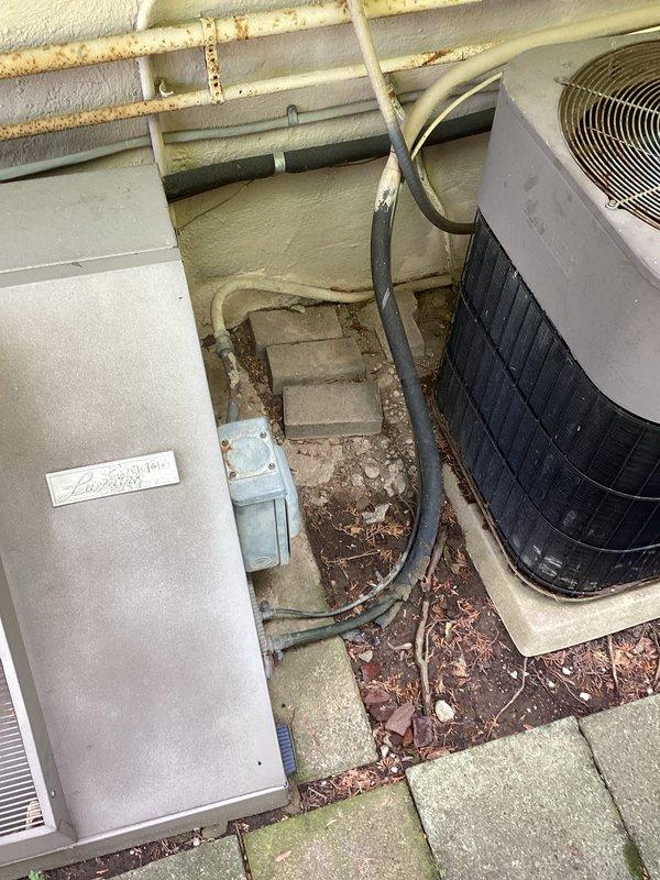 Conducted comprehensive site assessment for HVAC system replacement involving both outdoor and indoor equipment. Evaluated existing outdoor heat pump/air conditioning unit and electrical cabinet positioned on concrete pad, noting significant debris accumulation requiring clearance prior to installation. Assessed indoor furnace system located in basement mechanical room, including existing plenum, ductwork configuration, and condensate drainage system. Documented current equipment specifications and installation conditions through photographic records. Provided multiple replacement estimates covering air conditioning system upgrade and potential furnace replacement options to address aging equipment and improve system efficiency.