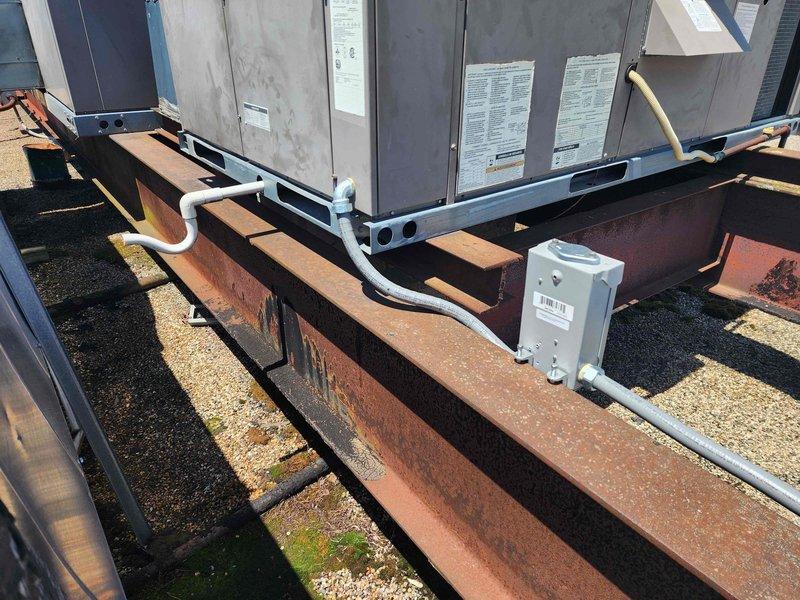 Completed electrical rewiring for rooftop HVAC units 8-9, replacing deteriorated wiring and conduit runs exposed to weather conditions. Installed new electrical disconnect box with appropriate weatherproof housing, secured all conduit routing along structural I-beam supports, and verified proper electrical connections to both commercial-grade HVAC units. All work performed in accordance with NEC standards for rooftop electrical installations.