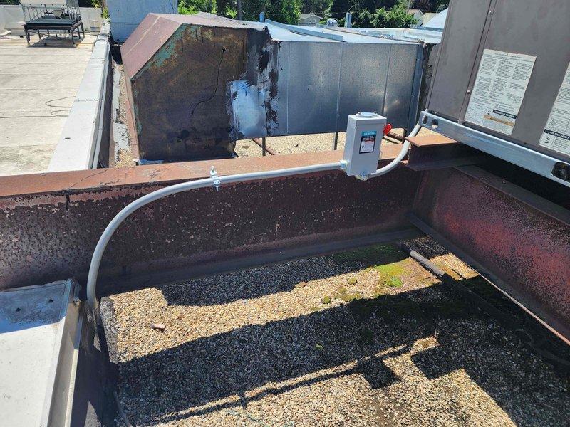 Completed electrical rewiring for rooftop HVAC units 8-9, replacing deteriorated wiring and conduit runs exposed to weather conditions. Installed new electrical disconnect box with appropriate weatherproof housing, secured all conduit routing along structural I-beam supports, and verified proper electrical connections to both commercial-grade HVAC units. All work performed in accordance with NEC standards for rooftop electrical installations.
