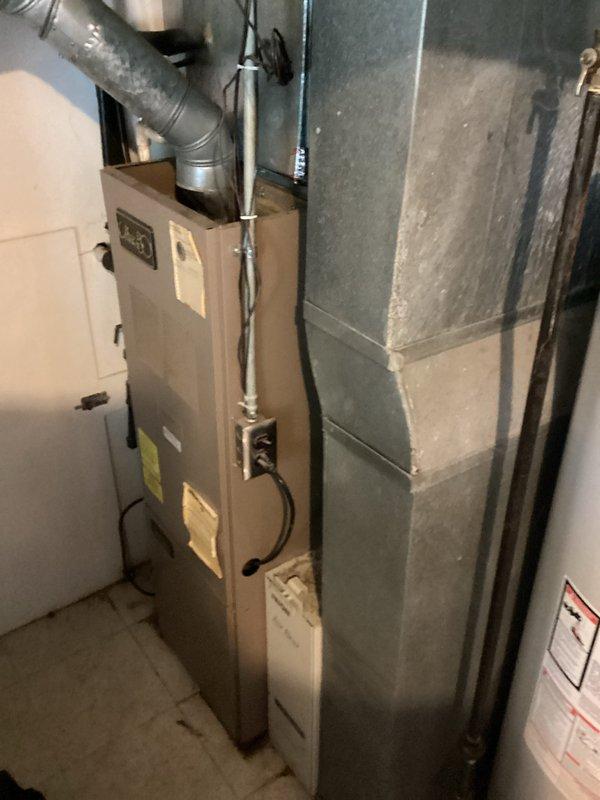 Conducted on-site evaluation of failed residential HVAC system in basement utility area. Assessed existing Ultra 80 furnace and associated air conditioning equipment that had reached end of service life and was no longer operational. Documented current system configuration including ductwork layout, electrical connections, condensate drainage, and venting infrastructure. Photographed equipment nameplate data, installation specifications, and surrounding mechanical room conditions to develop comprehensive replacement estimate for complete heating and cooling system.