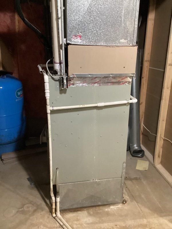 Provided estimate for air conditioning system replacement at residential property. Current unit is operational but experiencing refrigerant leak and contains obsolete R-22 refrigerant, with equipment age exceeding 10 years. Assessed existing furnace and ductwork configuration in basement utility area to determine compatibility requirements for new system installation.