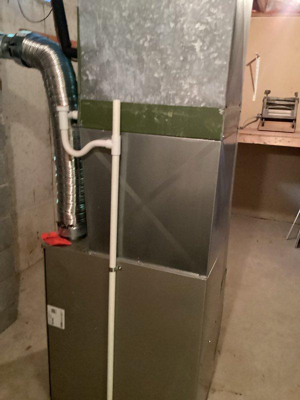 Evaluated a 28-year-old R22 air conditioning system with a failed condenser fan motor. Documented the outdoor condenser unit showing significant age-related weathering and the indoor furnace system, and provided an estimate for condenser fan motor replacement to restore cooling functionality.