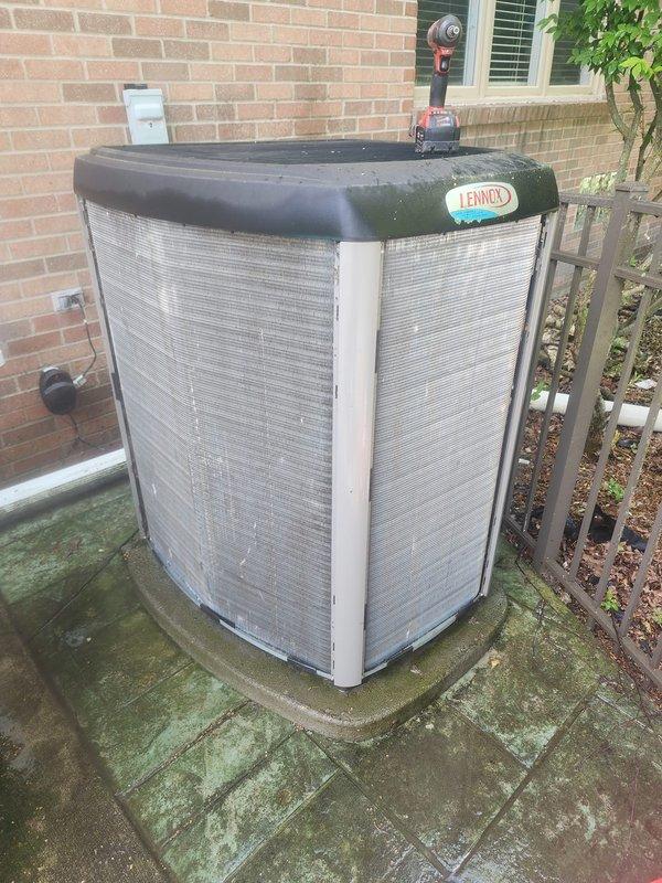 Responded to no cooling complaint on Lennox condensing unit. Upon arrival, confirmed outdoor fan motor was not operating while compressor attempted to run. Inspected unit exterior showing signs of age and environmental exposure with algae growth on pad and weathering on cabinet. Removed top panel and diagnosed failed condenser fan motor. Motor tested with no continuity and showed signs of bearing failure. Replaced defective fan motor with OEM equivalent, verified proper rotation and amperage draw within specifications. Checked capacitor values and found dual run capacitor reading low on fan side; replaced capacitor to ensure reliable operation. Cleaned condenser coils of accumulated debris and dust buildup to restore proper airflow and heat transfer efficiency. Verified all refrigerant line connections secure with no visible signs of leakage. Tested system operation through complete cooling cycle, confirmed proper compressor function, adequate airflow across coil, and temperature split