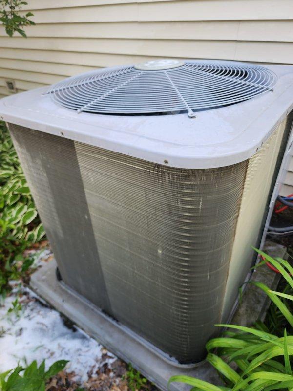 Completed preventive maintenance service on residential split-system air conditioning unit. Performed comprehensive inspection of outdoor condenser unit, documenting equipment condition including weathered cabinet panels and proper placement on composite pad. Accessed indoor air handler to inspect evaporator coil assembly, drain pan, and refrigerant lines. Noted drain pan showing signs of biological growth and mineral deposits requiring monitoring for proper condensate drainage. Verified refrigerant line connections and electrical wiring integrity as part of standard maintenance protocol.