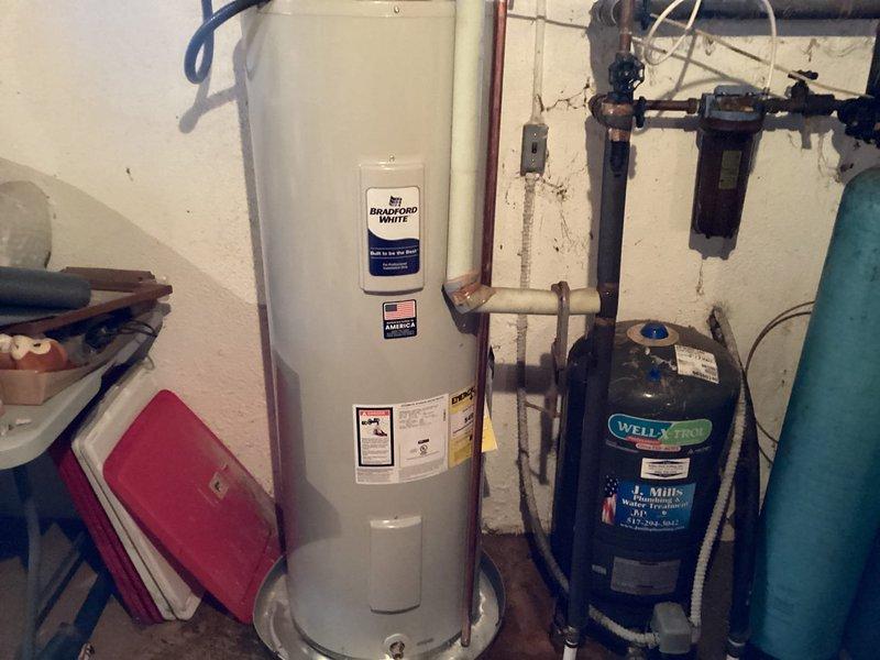 Successfully installed a new 50-gallon Bradford White electric water heater in the basement utility room. The installation included proper electrical connections with dedicated disconnect switch, copper supply line connections, and integration with the existing well pressure tank system. All work was completed to code specifications with appropriate shut-off valves and safety features installed.
