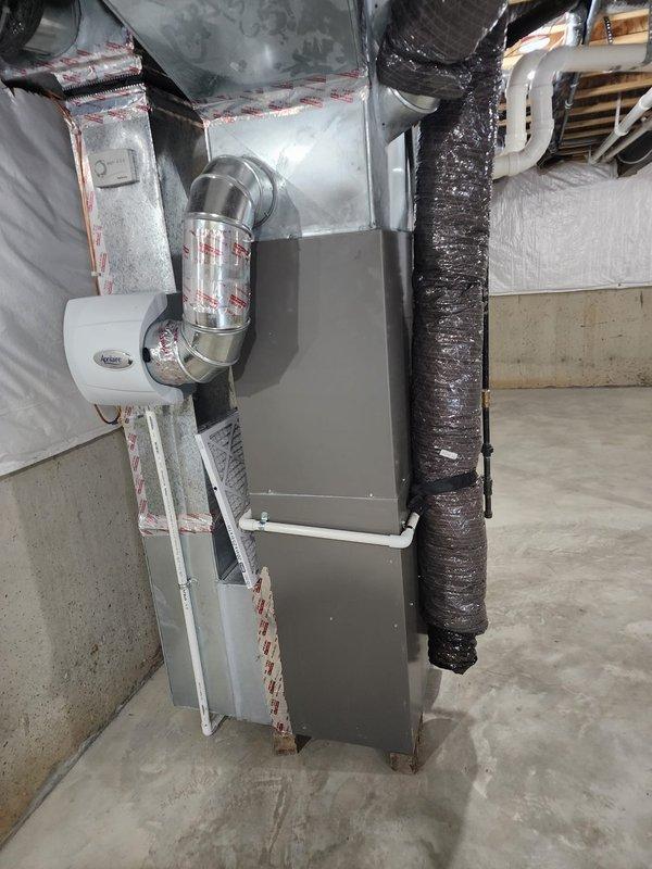 Completed installation of Lennox air conditioning system including new air handler unit in basement utility area. Connected metallic supply ductwork with proper insulation, installed condensate drain trap with PVC piping, and routed refrigerant lines with appropriate mounting and support brackets. System tested and operational upon completion.