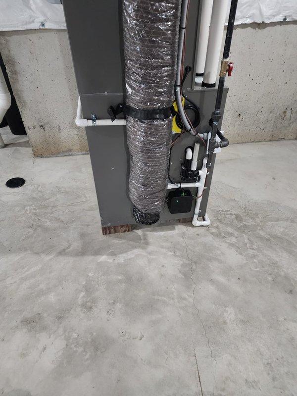 Completed installation of Lennox air conditioning system including new air handler unit in basement utility area. Connected metallic supply ductwork with proper insulation, installed condensate drain trap with PVC piping, and routed refrigerant lines with appropriate mounting and support brackets. System tested and operational upon completion.