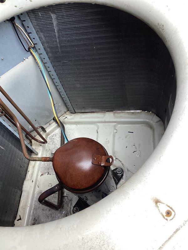 Responded to no cooling call on aging outdoor heat pump unit. Upon inspection, found unit with significant outdoor weathering, surface corrosion on copper refrigerant lines, and rust on compressor housing. Documented existing condition showing dirt accumulation in base pan, discolored exterior housing, and general operational wear consistent with 10+ years of service.