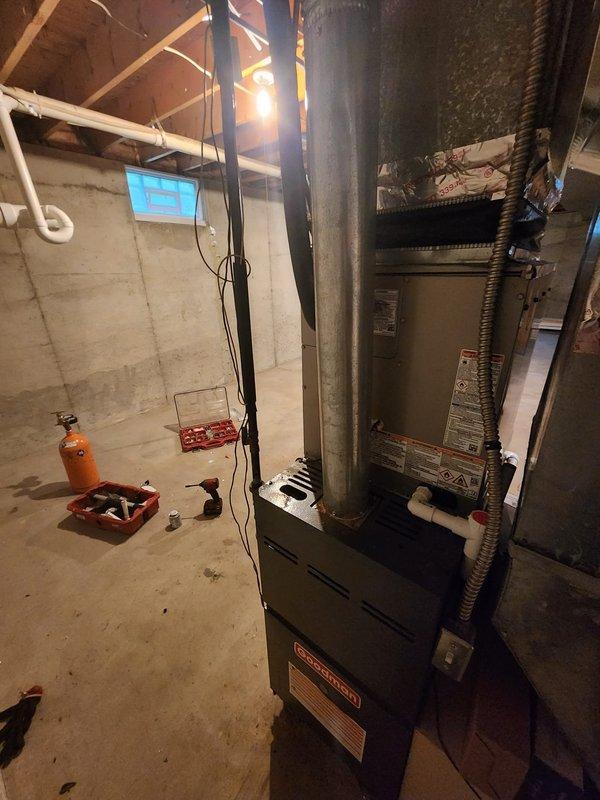 Completed installation of Bryant air conditioning system in residential basement mechanical room. New AC unit installed and connected to existing furnace infrastructure with proper ductwork integration and electrical connections. Service financing documentation processed and customer identification verified on file.