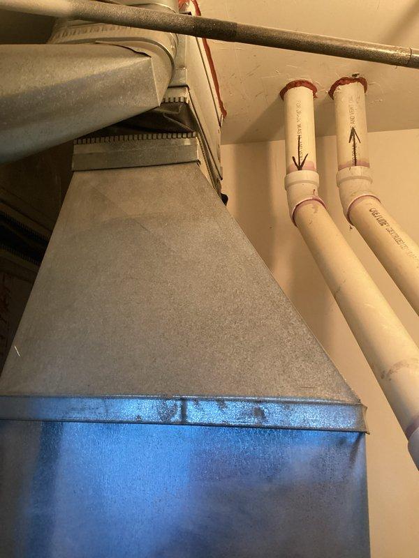 Provided comprehensive estimate for complete air conditioning system replacement at front of condominium unit. Existing equipment over 20 years old and non-operational, requiring full system change-out including outdoor condensing unit, indoor air handler, refrigerant lines, and associated ductwork connections. Assessed current installation including existing duct configuration, drain line routing with PVC condensate piping, electrical supply requirements, and equipment placement constraints in confined mechanical space.