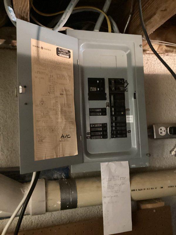 Completed HVAC replacement estimate for residential air conditioning system. Documented existing outdoor condensing unit located on concrete pad with electrical disconnect, assessed electrical panel in basement utility area showing current A/C circuit configuration, and photographed installation conditions including existing conduit routing and available workspace for replacement equipment.