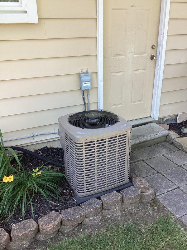 Completed HVAC replacement estimate for residential air conditioning system. Documented existing outdoor condensing unit located on concrete pad with electrical disconnect, assessed electrical panel in basement utility area showing current A/C circuit configuration, and photographed installation conditions including existing conduit routing and available workspace for replacement equipment.