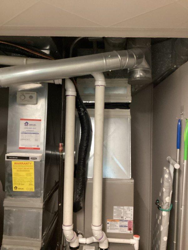 Conducted on-site evaluation for tankless water heater replacement in lower level of approximately 70-year-old residential property. Assessed existing conventional tank-style water heater installation, documenting current plumbing configuration including copper supply lines, venting system with galvanized ductwork, and proximity to existing HVAC equipment. Photographed mechanical room layout, pipe routing, electrical access points, and available clearances for future tankless unit installation. Evaluated structural considerations for mounting requirements, gas line capacity or electrical service needs, condensate drainage options, and venting modifications necessary for conversion from atmospheric to sealed combustion system. Provided estimate for complete removal of existing tank unit and installation of new tankless water heating system with appropriate code-compliant connections.