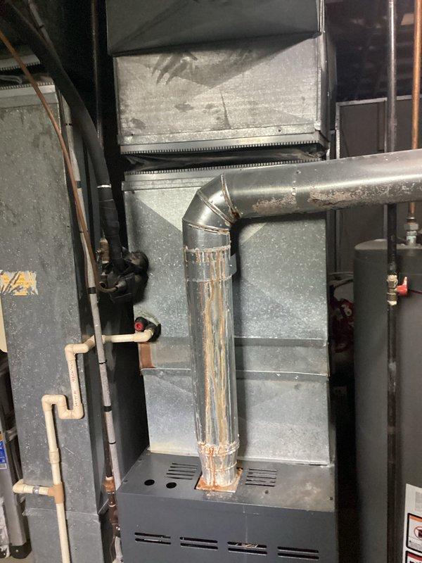 Conducted comprehensive assessment of existing HVAC system for replacement estimate. Evaluated 37-year-old air conditioning unit located outside and 11-year-old furnace system in basement. Both systems currently operational but nearing end of service life. Documented equipment specifications, ductwork conditions including visible rust deterioration on vertical duct sections, and overall system configuration. Photographed existing furnace unit, associated ductwork, copper piping, and gas line connections to provide accurate replacement specifications and identify any necessary modifications for new equipment installation.