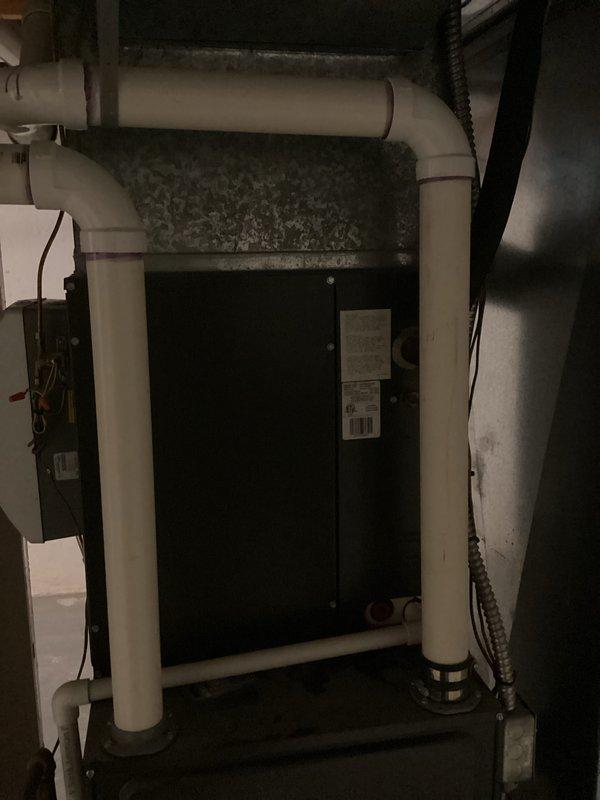 Provided estimate for complete air conditioning system replacement at residential property. Current outdoor condenser unit and indoor air handler are non-operational, with equipment age estimated to match home construction date. Assessment included evaluation of existing basement-mounted air handler with PVC condensate drainage system and exterior condenser unit positioned on concrete pad against home's foundation.