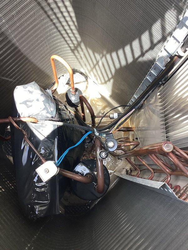 Responded to no cooling complaint on 10-year-old mini-split system installed above garage. Upon arrival, verified unit was still producing cooling but operating below optimal performance. Performed comprehensive visual inspection of evaporator coil and compressor assembly. Photographed evaporator coil showing normal fin condition with no visible ice formation or significant debris accumulation. Inspected outdoor compressor unit and refrigerant line connections, confirming copper piping integrity and proper insulation on suction line. Observed all major components including compressor, refrigerant lines, and condensate drainage system. System maintained cooling operation throughout inspection, suggesting intermittent issue or performance degradation rather than complete failure. Advised customer of findings and provided documentation via photographs for future reference.