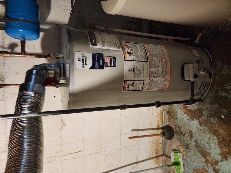 Completed installation of a 50-gallon tank-style gas water heater in residential basement utility room. Replaced and rerouted gas supply lines from furnace to water heater, kitchen stove, and dryer to ensure proper gas distribution throughout the home. All connections were pressure tested and inspected for safety compliance, with proper venting installed to manufacturer specifications.
