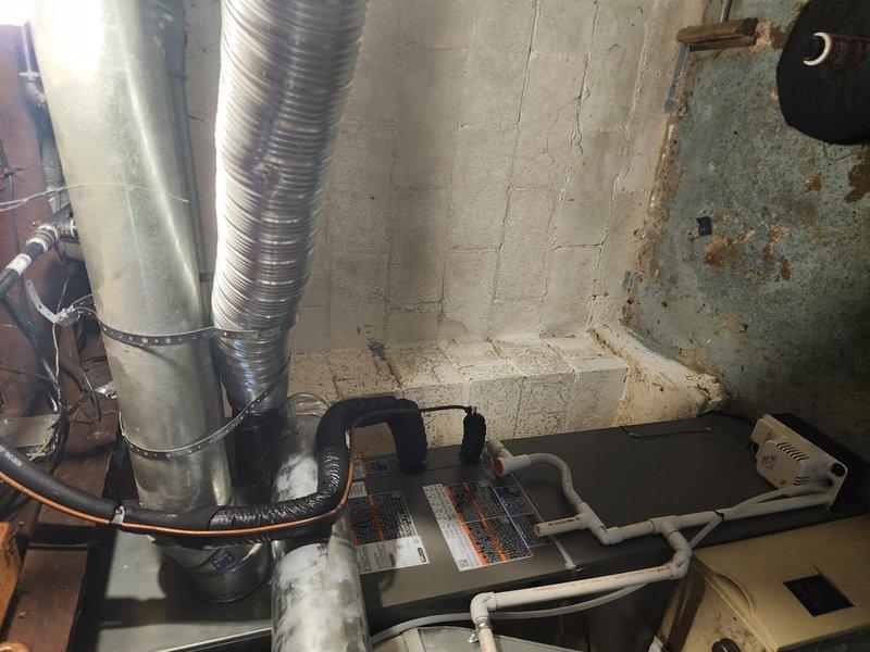 Completed installation of a 50-gallon tank-style gas water heater in residential basement utility room. Replaced and rerouted gas supply lines from furnace to water heater, kitchen stove, and dryer to ensure proper gas distribution throughout the home. All connections were pressure tested and inspected for safety compliance, with proper venting installed to manufacturer specifications.