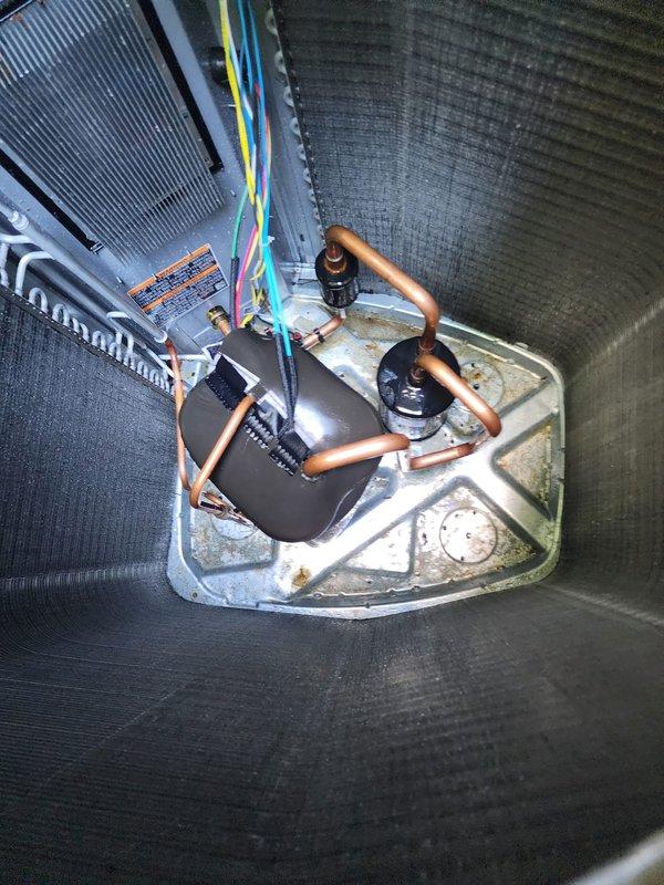 Completed scheduled air conditioning maintenance service on residential split system. Performed comprehensive inspection of outdoor condenser unit and indoor air handler located in attic space. Outdoor unit found in operational condition with proper airflow through coil fins and fan assembly. Indoor air handler inspected with attention to drain pan showing signs of normal condensation accumulation and rust staining consistent with system age. Verified refrigerant lines and connections for proper insulation and secure fittings. System tested and confirmed cooling operation within normal parameters.