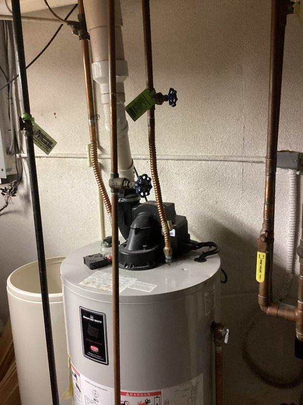 Completed estimate for replacement of existing 50-gallon residential water heater with new Bradford White unit. Assessed current installation including copper supply piping, corrugated flexible connectors, shut-off valves, pressure relief valve with discharge line, and all associated fittings in basement utility area. Documented existing plumbing configuration, PVC drainage system, and mechanical room layout with photographs for comprehensive replacement proposal.