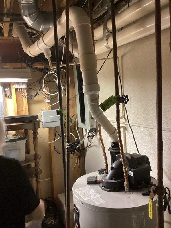 Completed estimate for replacement of existing 50-gallon residential water heater with new Bradford White unit. Assessed current installation including copper supply piping, corrugated flexible connectors, shut-off valves, pressure relief valve with discharge line, and all associated fittings in basement utility area. Documented existing plumbing configuration, PVC drainage system, and mechanical room layout with photographs for comprehensive replacement proposal.