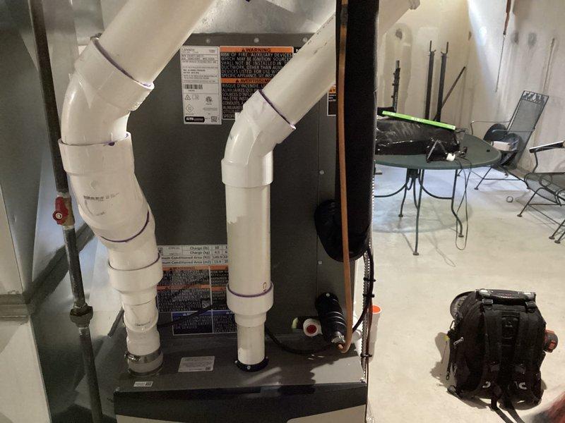 Completed installation of Lennox air conditioning system in residential basement location. Installed new air handler unit with proper refrigerant line connections, secured PVC condensate drainage piping with appropriate fasteners, and verified all electrical connections and system controls are functioning correctly.