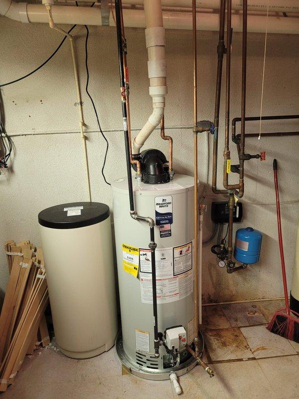 Completed installation of a 50-gallon power vent water heater in basement utility area. Removed existing unit and installed new water heater with proper copper piping connections, including hot and cold water supply lines, pressure relief valve discharge piping, and gas line connections. Configured power vent system with appropriate PVC venting through exterior wall to ensure safe combustion exhaust. Installed expansion tank and integrated connections with existing plumbing infrastructure, including coordination with water softener system. Verified all connections for leaks, tested gas line integrity, confirmed proper venting operation, and ensured unit fired correctly. System brought up to code with appropriate shut-off valves and pressure relief components. All work completed within scheduled timeframe with successful operational testing confirmed before departure.
