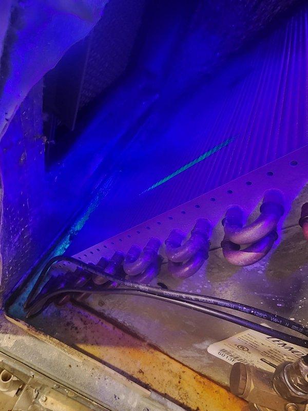 Responded to no cooling complaint on 13-year-old air conditioning system located in basement. Upon inspection, performed UV light examination of evaporator coil and heat exchanger assembly, revealing significant deterioration and corrosion on metal housing components with visible rust staining along frame edges. Evaporator coil showed signs of age-related wear consistent with system's service life. Assessed overall system condition and determined unit had reached end of effective service life. Documented findings with UV inspection photography. Discussed repair versus replacement options with customer and provided equipment replacement estimate as requested due to age and condition of existing system.