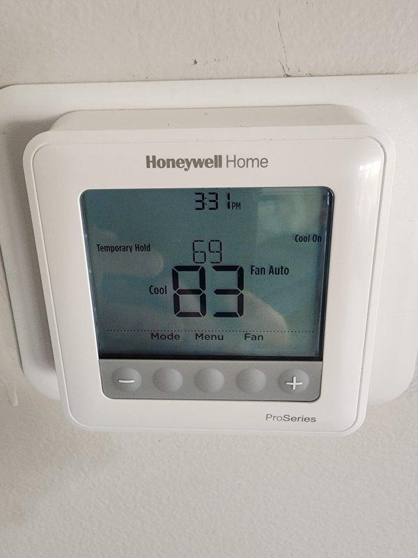 Completed full HVAC system installation including new Lennox furnace and air conditioning condenser unit. Installed Honeywell Home ProSeries digital thermostat with programmable temperature control and auto fan settings. Removed existing humidifier from system per customer request. Positioned outdoor condenser unit on concrete pad in side yard alcove with proper clearances maintained. Verified all electrical connections, refrigerant lines, and condensate drainage. System tested and operating within manufacturer specifications with cooling mode engaged and thermostat communicating properly with equipment.