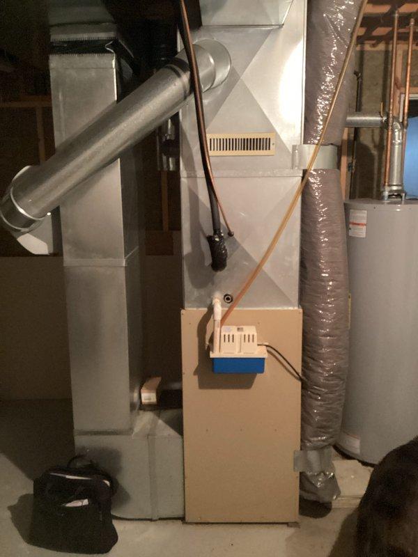 Conducted on-site evaluation of 28-year-old residential central air conditioning system originally installed in 1998. System currently operational but showing signs of declining performance. Assessed outdoor condenser unit and indoor evaporator coil configuration in basement mechanical room. Documented existing HVAC infrastructure including air handler, ductwork, and electrical connections. Photographed equipment placement and surrounding mechanical systems to prepare comprehensive replacement estimate for complete AC system upgrade.