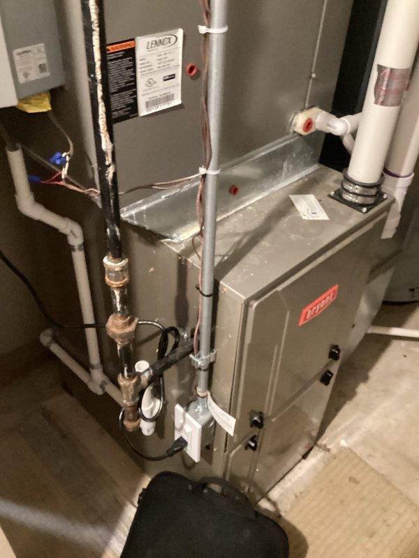 Completed HVAC system assessment for equipment replacement estimate in residential basement utility space. Evaluated existing Bryant furnace and Lennox air handler installation, documented current system configuration including ductwork plenum, condensate drain lines, refrigerant piping, and electrical connections. Photographed equipment conditions, component placement, and existing infrastructure to prepare comprehensive replacement proposal for complete system upgrade.