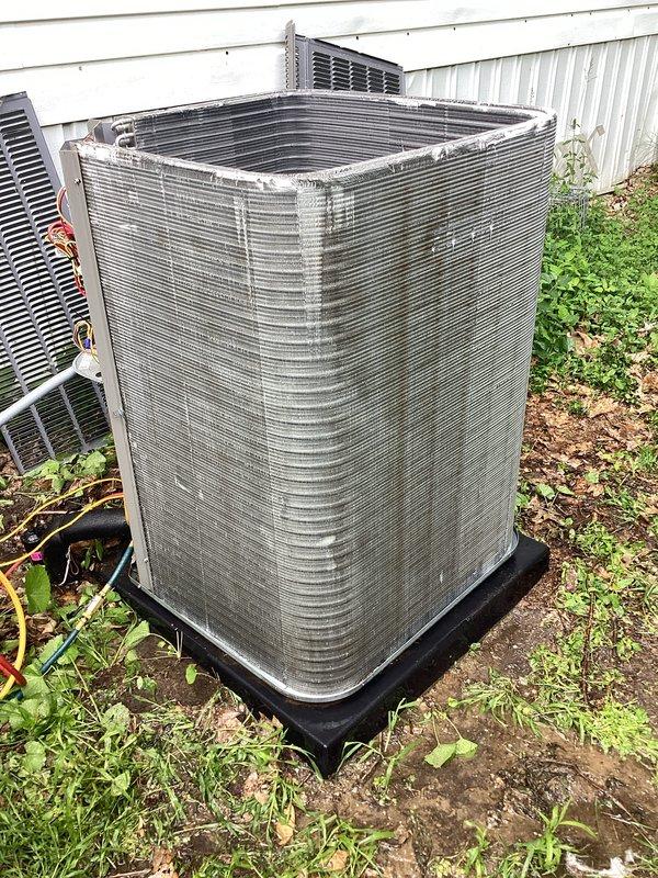 Responded to no-cooling complaint on 1-year-old residential air conditioning system located at rear of property. Upon arrival, confirmed unit was running but delivering warm air to occupied space with rising indoor temperatures. Performed comprehensive diagnostic evaluation of outdoor condensing unit and associated components. Visual inspection revealed compressor operation and electrical connections intact, with refrigerant lines and coil assembly showing normal oxidation consistent with equipment age. Conducted system performance testing and identified root cause of cooling failure. Due to urgency of situation and health considerations, documented findings with photographic evidence showing internal compressor assembly, refrigerant line connections, and external condenser unit condition. System components including evaporator/condenser coil, electrical wiring, and mounting hardware were assessed for proper installation and operational status.