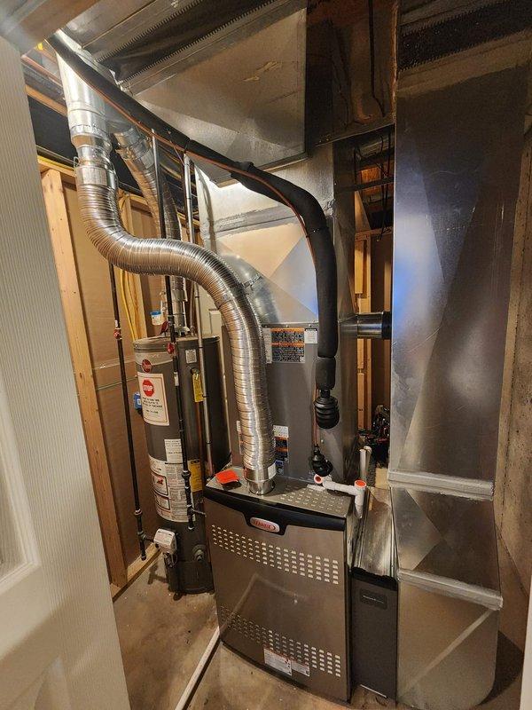 Completed full HVAC system installation in residential basement utility area, including new furnace unit, air handler, and water heater with associated ductwork and plumbing connections. Installed flexible aluminum ductwork from furnace to ventilation system, configured PVC plumbing lines with shut-off valves, and verified all equipment properly labeled and secured within existing wooden frame structure. System tested and operational upon completion.