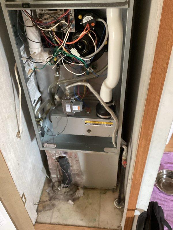 Completed estimate for air conditioning system replacement at residential property. Current unit is operational but performing poorly, with age unknown. Inspection revealed furnace installation in interior closet with visible signs of moisture damage on flooring and lower unit panels, along with water staining around base of equipment. Documented existing vertical furnace configuration with exposed wiring connections, blower assembly, and PVC condensate drainage system. Assessed utility space constraints and existing infrastructure to provide comprehensive replacement options for aging HVAC system showing deterioration from extended service life and moisture exposure.