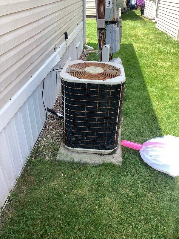 Completed air conditioning replacement estimate for residential property. Assessed existing outdoor condensing unit showing significant age-related deterioration, weathering, and exterior component wear. Unit positioned on concrete pad in narrow side yard with adequate clearance between structures. Evaluated electrical service including meter, disconnect box, and associated wiring mounted on utility pole, noting visible rust and aging on existing electrical panel components. Documented current system configuration and site conditions through photographs for estimate preparation. Homeowner to review replacement options and make final decision regarding equipment selection and installation scope.