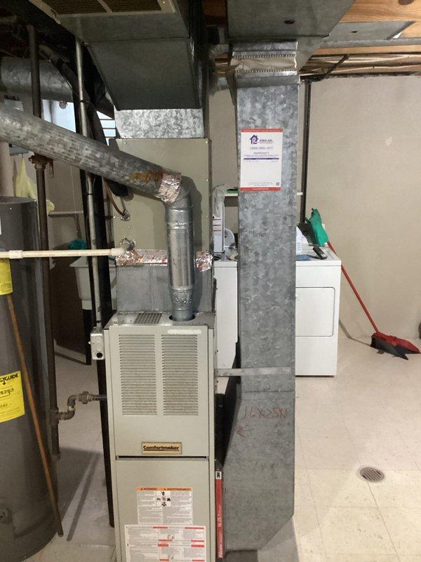 Completed comprehensive HVAC system evaluation for air conditioning replacement estimate in residential basement utility area. Assessed existing ComfortMaker furnace unit, ductwork configuration, and mechanical room layout to determine optimal replacement equipment specifications and installation requirements. Documented current system conditions including insulated ductwork, copper piping connections, and clearance parameters for new AC equipment installation.