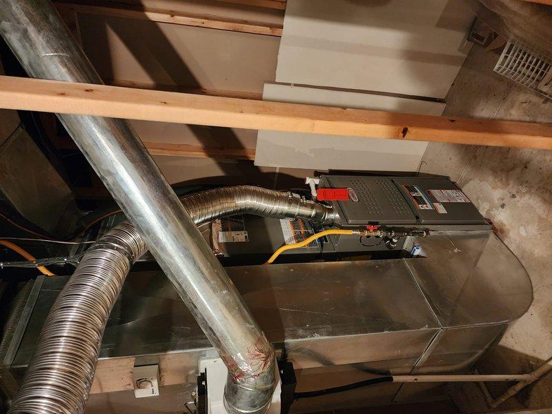 Completed full HVAC system installation including Lennox 80% efficiency gas furnace, central air conditioning unit, and T6 programmable thermostat in residential basement mechanical room. Installation included all necessary ductwork connections, electrical wiring, gas line hookup, condensate drain lines, and refrigerant line sets between indoor and outdoor components. System was tested for proper operation, airflow verified, thermostat programmed and calibrated, with all components functioning within manufacturer specifications upon completion.