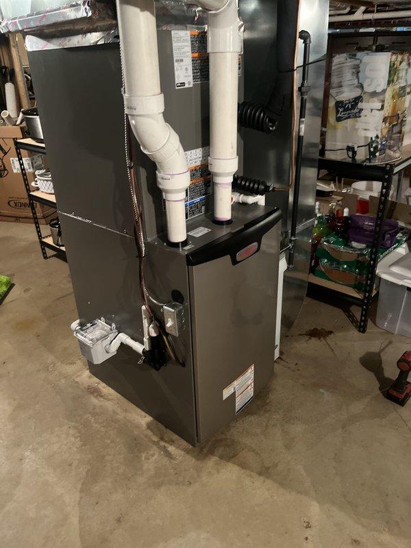 Completed full HVAC system installation including Lennox furnace and air conditioning unit with associated venting and drainage systems. Installed S40 thermostat for primary system and Ecobee thermostat for lower zone system to provide dual-zone climate control capability.

The installation involved mounting the new Lennox furnace in the basement mechanical room with proper clearances and securing all supply and return ductwork connections. Ran white PVC exhaust and intake venting through the structure per manufacturer specifications for high-efficiency condensing operation. Connected condensate drainage line with appropriate trap and routing to approved drain location. Integrated black flexible ductwork to existing distribution system and verified proper airflow. Completed all electrical connections including dedicated circuits and low-voltage control wiring.

Installed outdoor condensing unit with refrigerant line set connections, ensuring proper brazing techniques and leak-free join