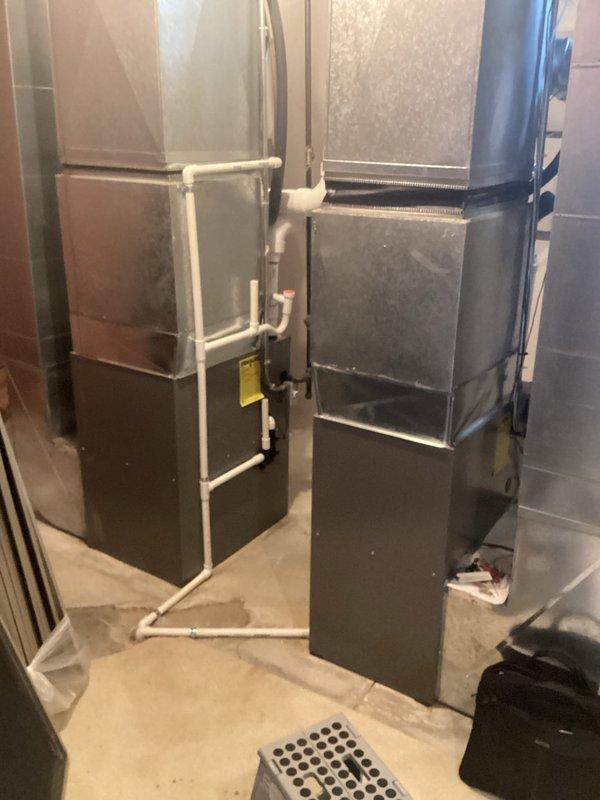 Completed comprehensive estimate for replacement of dual air conditioning system with zoning capabilities serving three zones. Evaluated existing outdoor condenser units positioned against exterior brick wall, including assessment of refrigerant line routing, electrical disconnects, and equipment placement on concrete pads. Assessed indoor air handling equipment consisting of two vertical furnace/air handler units in basement mechanical room, including evaluation of existing ductwork configuration, PVC condensate drainage system, and electrical connections. Documented current system specifications and photographed equipment for replacement proposal development.