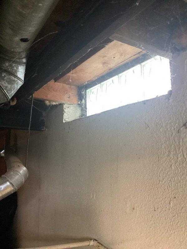 Responded to service call for non-operational air conditioning system that was determined to be beyond economical repair. Conducted comprehensive assessment of existing 28-year-old AC unit located outside and 28-year-old furnace system installed in basement. Documented current equipment configuration including ductwork, plenum connections, electrical components, and control systems through photographic inspection. Evaluated basement installation space, noting existing galvanized ductwork with metal strapping, beige metal plenum cabinet, gray control box with electrical panel, concrete flooring, and foundation walls. Assessed window opening and ventilation requirements in utility area. Prepared detailed replacement estimate for complete HVAC system upgrade including both air conditioning and furnace units to restore climate control functionality to the residence.
