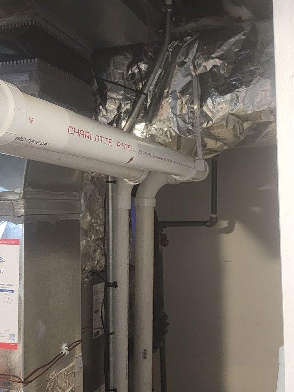 Insulated plenum assembly in mechanical space to improve system efficiency and prevent condensation issues. Applied foil-faced insulation wrap to exposed ductwork and plenum connections, securing all materials with proper fasteners and ensuring complete coverage around HVAC distribution components. Verified all insulation seams were properly sealed and that clearances were maintained around existing PVC piping, water heater, and electrical components in the confined space.