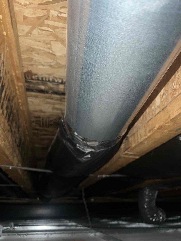 Responded to service call for clicking noise from compressor and moisture discharge from supply vents on one-year-old system. Inspected outdoor condensing unit and confirmed clicking sound during compressor cycling, determined to be normal relay operation within acceptable parameters. Investigated moisture complaint and identified inadequate duct insulation in unconditioned space allowing condensation formation on cold supply ductwork. Documented existing insulation deficiencies with photos showing exposed and improperly wrapped ductwork in attic/crawl space area. Recommended additional insulation wrap and proper vapor barrier installation on supply ducts to eliminate condensation issues. System operating and providing adequate cooling at time of inspection.