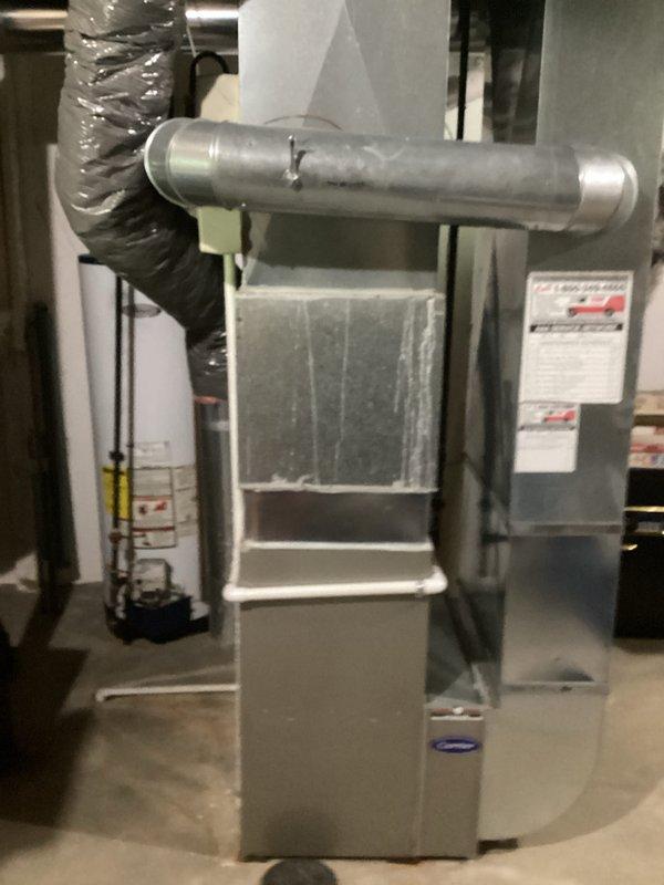 Conducted on-site evaluation of existing HVAC system to provide full replacement estimate for furnace and air conditioner. Inspected current equipment installation in basement utility area, including gray metal furnace unit with mounted air handler, ductwork connections, and associated components. Documented existing system configuration with photographs showing furnace assembly, horizontal and flexible ductwork, filter cabinet, and overall installation layout. Assessed equipment condition, noting current system is operational. Gathered necessary measurements and specifications to prepare comprehensive replacement quote for complete heating and cooling system upgrade.