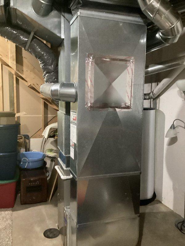 Conducted on-site evaluation of existing HVAC system to provide full replacement estimate for furnace and air conditioner. Inspected current equipment installation in basement utility area, including gray metal furnace unit with mounted air handler, ductwork connections, and associated components. Documented existing system configuration with photographs showing furnace assembly, horizontal and flexible ductwork, filter cabinet, and overall installation layout. Assessed equipment condition, noting current system is operational. Gathered necessary measurements and specifications to prepare comprehensive replacement quote for complete heating and cooling system upgrade.